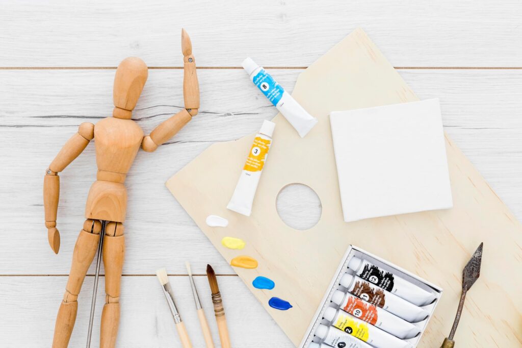 top view paint supplies with wooden mannequin (1)